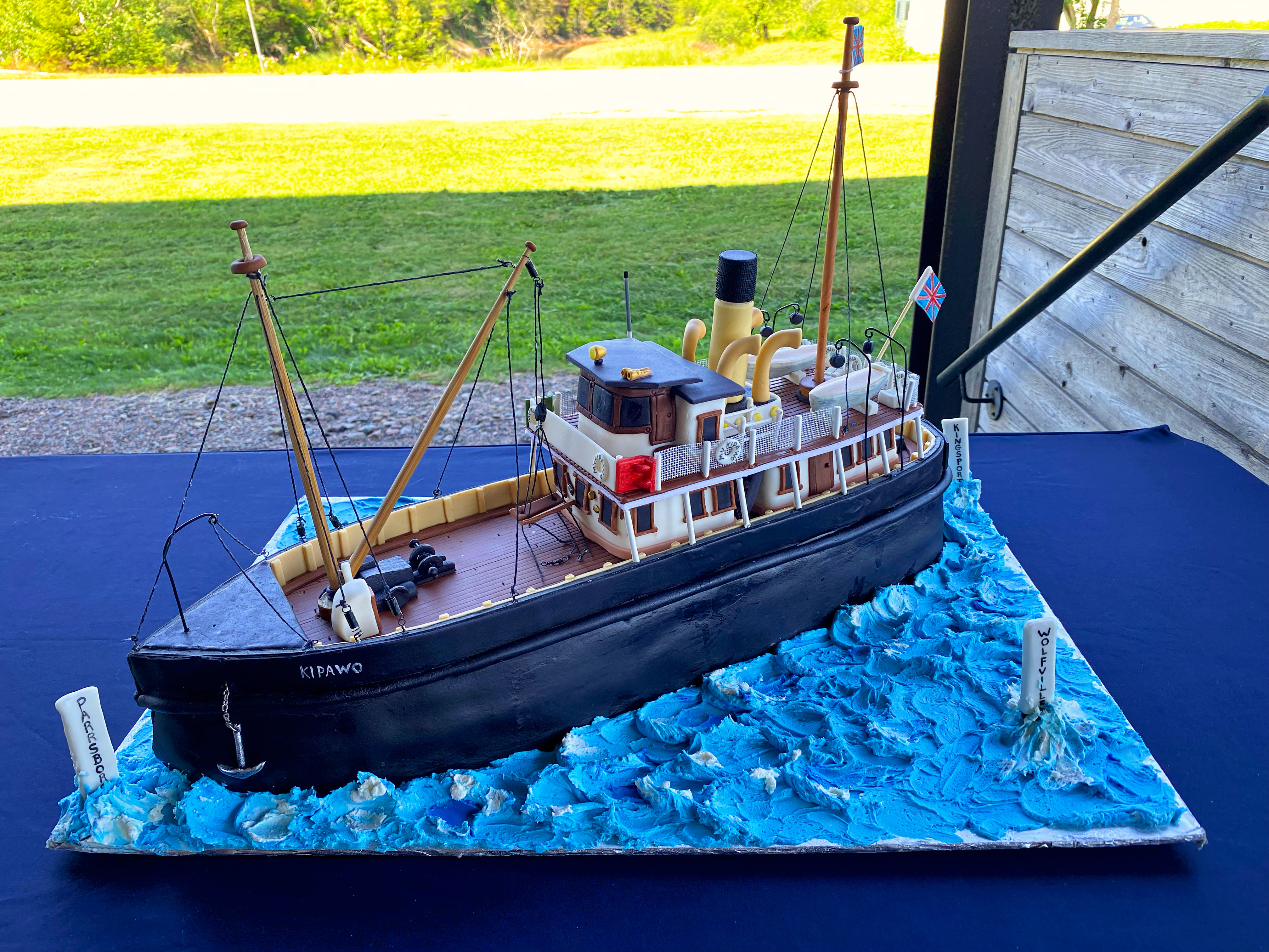 A cake in the shape of the former ferry MV Kipawo sits on a table.